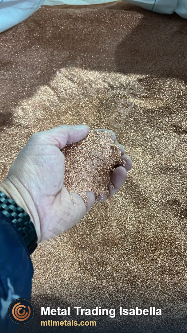 Hand showing crushed copper granulate